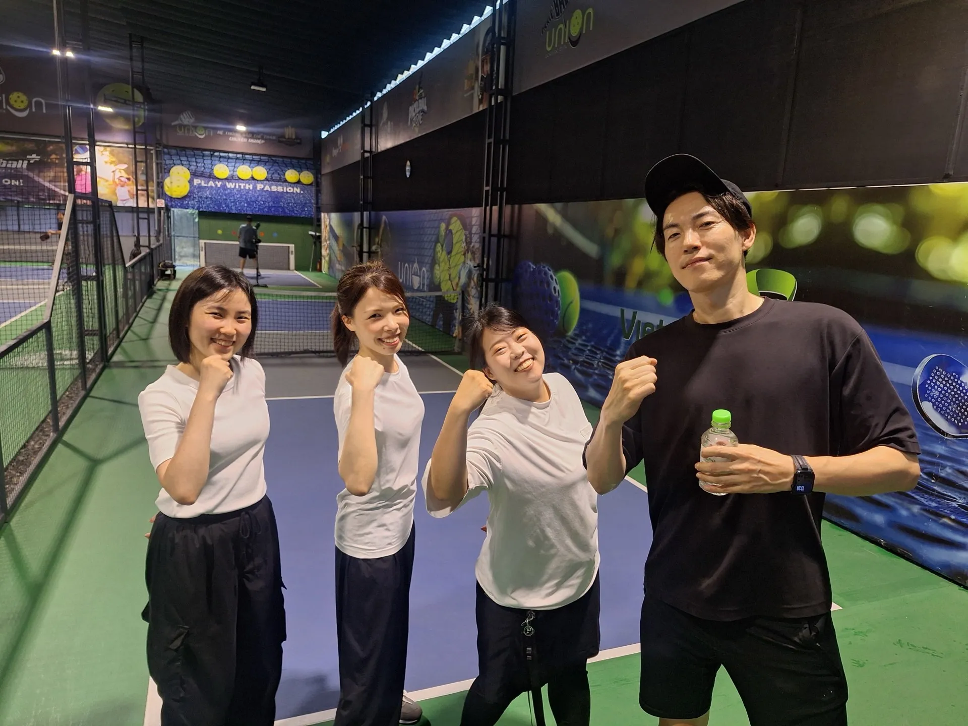 ピックルボールのコートでガッツポーズをとるノマドニアのメンバー